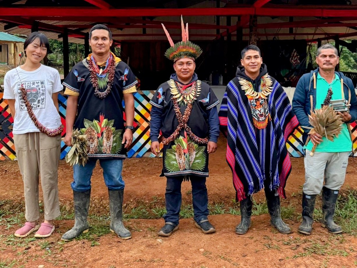 Min with Taita Miguel Mavisoy, Taita Leonardo Jacanamejoy and family in front of the maloca